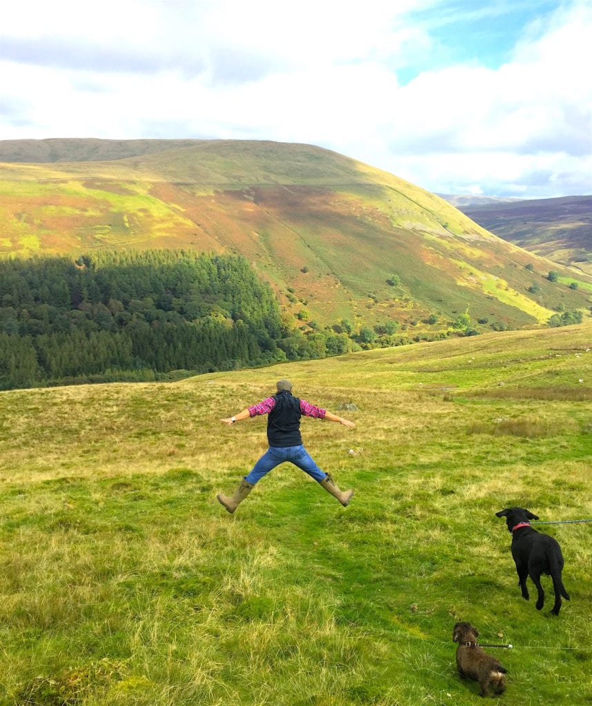 Man jumping in the air on a dog walk in the Yorkshire Dales